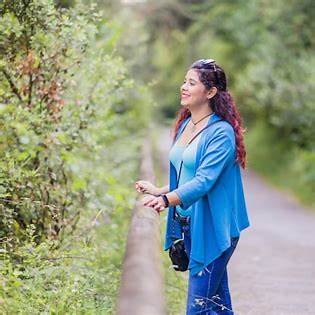 Woman standing quietly in nature, reflecting after realizing she forgot to take care of herself
